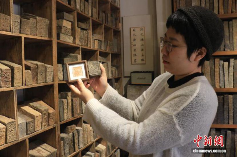 马雨展示根据古砖纹样制作的文创产品。