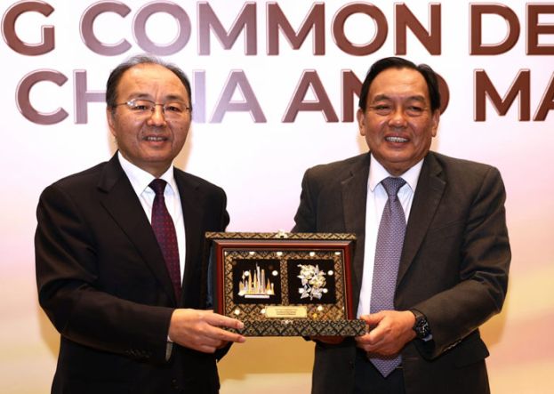 中国驻马大使欧阳玉靖(左)赠送纪念品予阿旺比米。