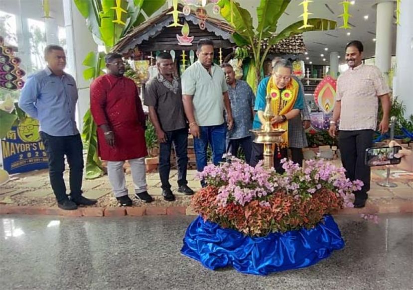 古晋南市市长拿督黄鸿圣为该局举办的2025年屠妖节庆祝会点上光明灯时摄。