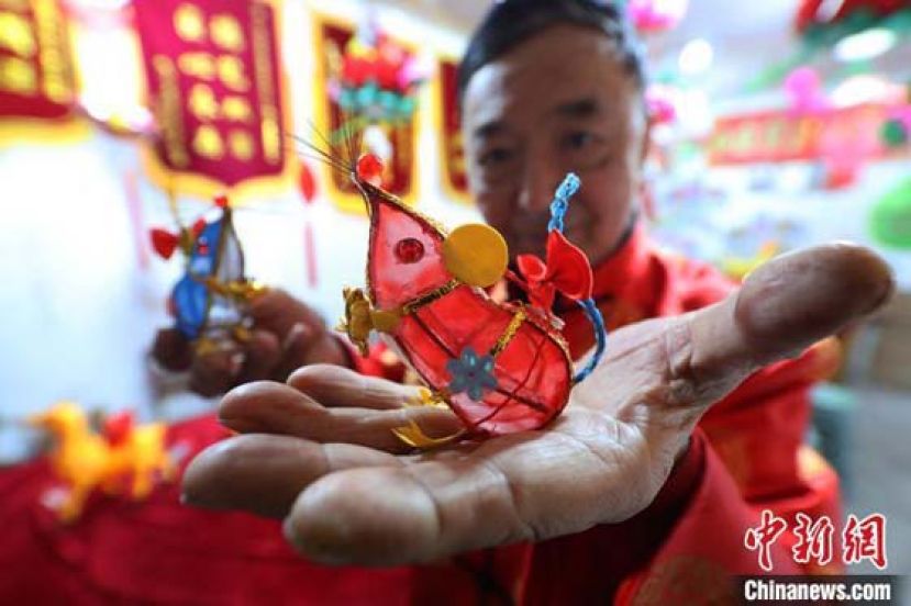 南京秦淮花灯传承艺人曹真荣展示他设计制作的&ldquo;掌中鼠&rdquo;迷你花灯。