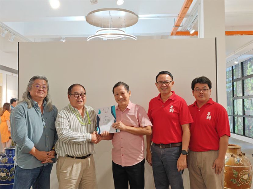 首奖得主麦成发（中）从裕光眼镜集团创办人蔡振强（左二）的手中接过奖状及一千令吉奖金。由此赛事的其中一位评审砂摄影协会顾问刘德义（左一）、筹委会主席萧钿录（右二）及砂文创协会主席蔡集淞（右一）见证。