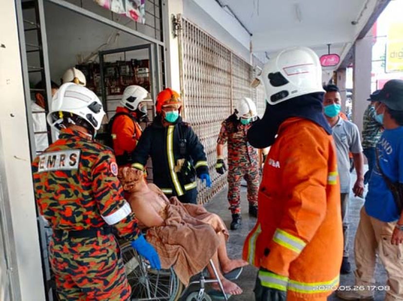 救援人员将华裔抬出店屋外。