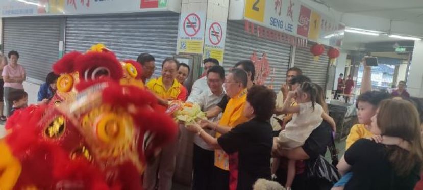 在古晋南市市议员郑志国（右三）等的陪同下，古晋南市市长拿督黄鸿圣接收福品时影。