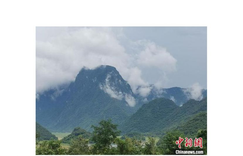 东方俄贤岭朦胧的雾气环绕青山，美如一副山水画。
