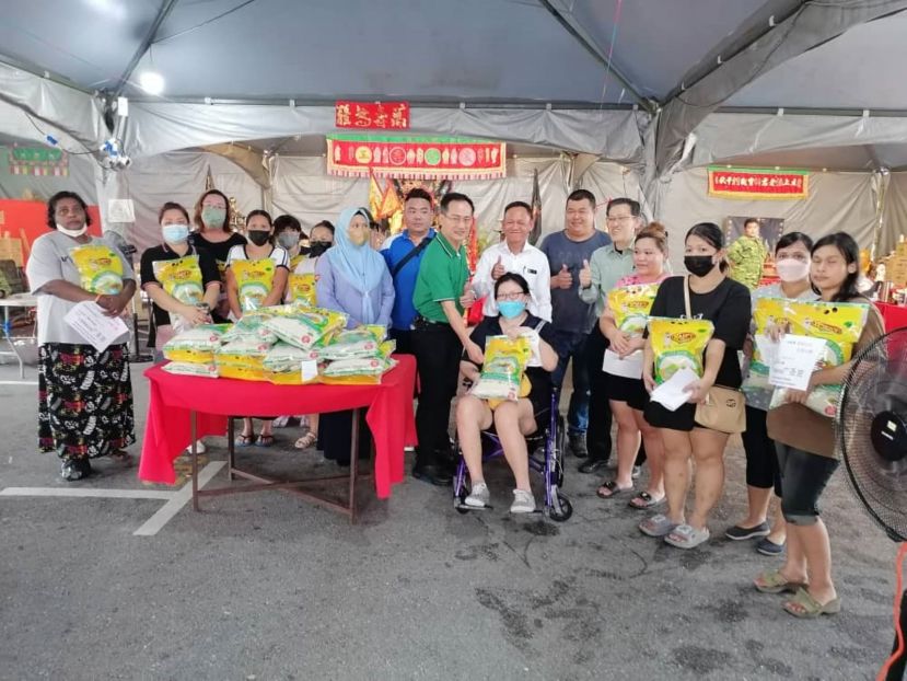 辉盛花园广圣宫主席林志雄（右8）派白米给弱势单亲妈妈；右7起为见证者社险砂局长陈邦正、副主席刘善通及薛华东。