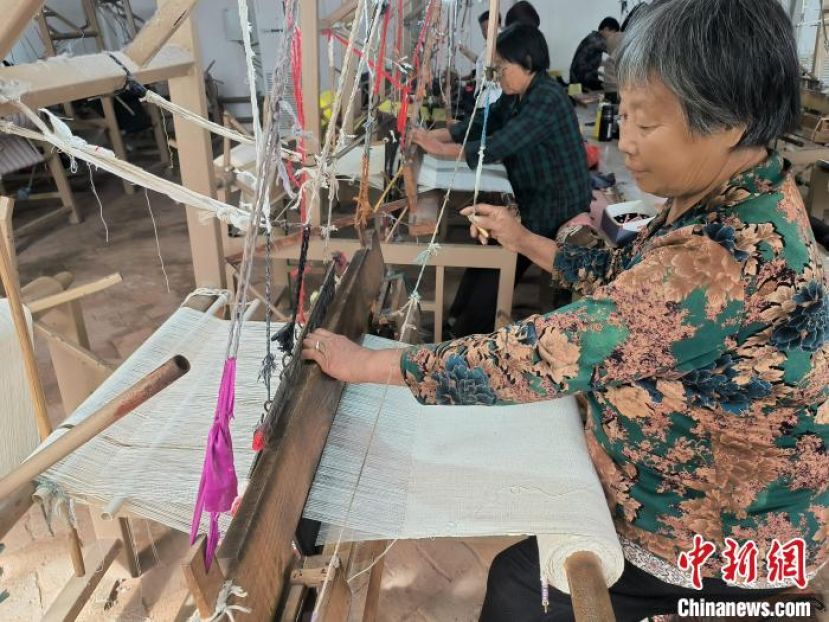 河北省赞皇县原村土布研发生产基地内，&ldquo;织娘&rdquo;们正在用老式织布机织布。