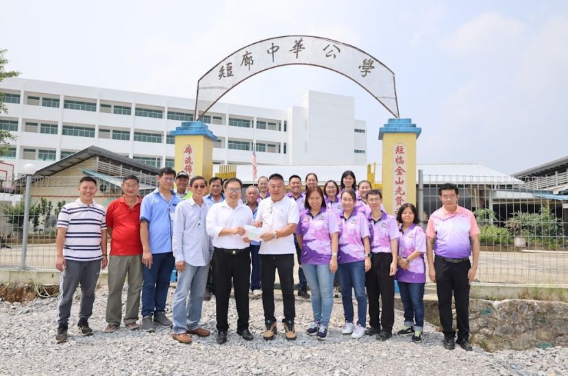 实旦宾区国会议员张健仁（左5）在校长、老师及校董们的陪同和共同见证下，移交李氏基金会的支票予短廊中华公学校董会主席兼新校舍建委会主席李思兴（中）。左1为张健仁特别助理沈杰龙；左4为建校委员会顾问李仁赵；右5为校长黄灵妮。