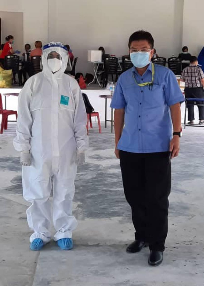 砂地方政府与房屋部公共环境卫生组主任比里苏章（右）监督伦乐瑟巴哥1区及2区的第二次逆转录聚合酶链反应。