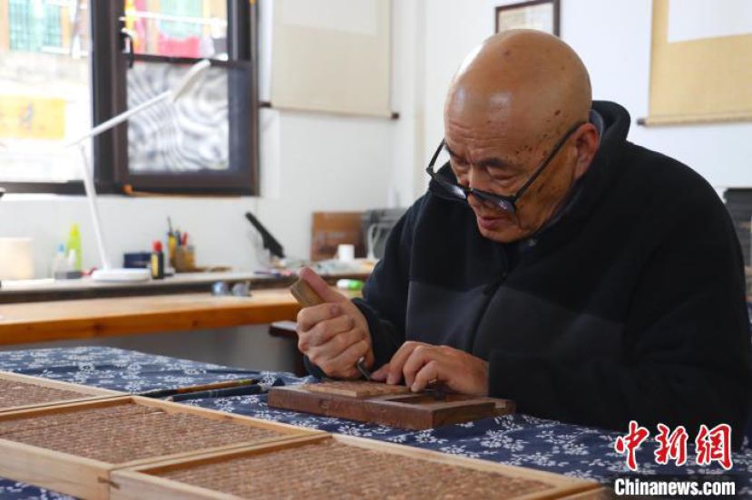 王钏巧用刻刀雕刻木活字。