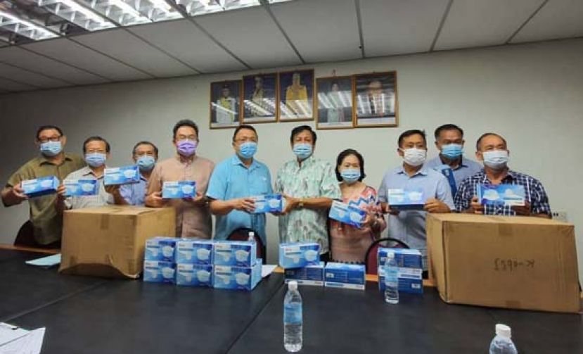 古晋中华小学校董会主席拿督王长福（右5）移交3万个口罩予晋汉连省津贴华小董联会会长蔡文铎（左5）。右起为董联会理事本固鲁刘金昇，联络谢维光，秘书本固鲁贝文美及署理会长田松茂，右起则为副财政蔡明新，理事吴瑞梁，四小监学吴孟敦，及拿督王长福夫人钱秀芳。