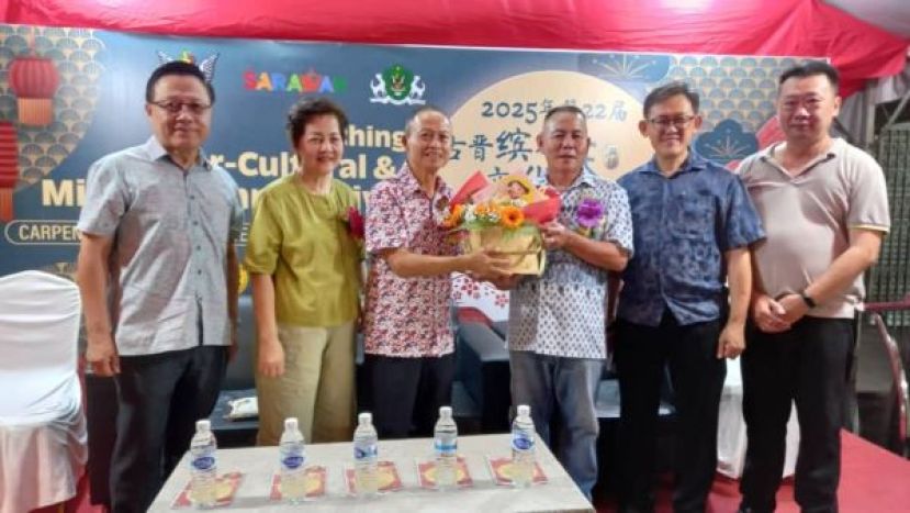  庆典大会会长甲必丹林传政（右3）赠月饼礼蓝予主宾拿督曾长青。左起是陈瑞光、拿汀孙美惜；右起为筹委吕世新、顾问薛华东。
