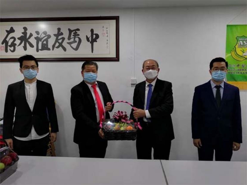  亚洲中医技职学院院长江宗兴（左2）赠送水果礼蓝予拿督刘义华（右2）；左为该学院老师江邦发；右是主任江邦仲。