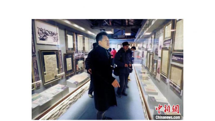 未立学在报刊博物馆内向游客介绍。
