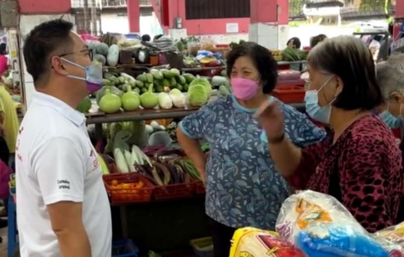 砂人联党青年总团长兼柏拉旺区候任议员程明智（左）走访拉让花园市集聆听群众心声。