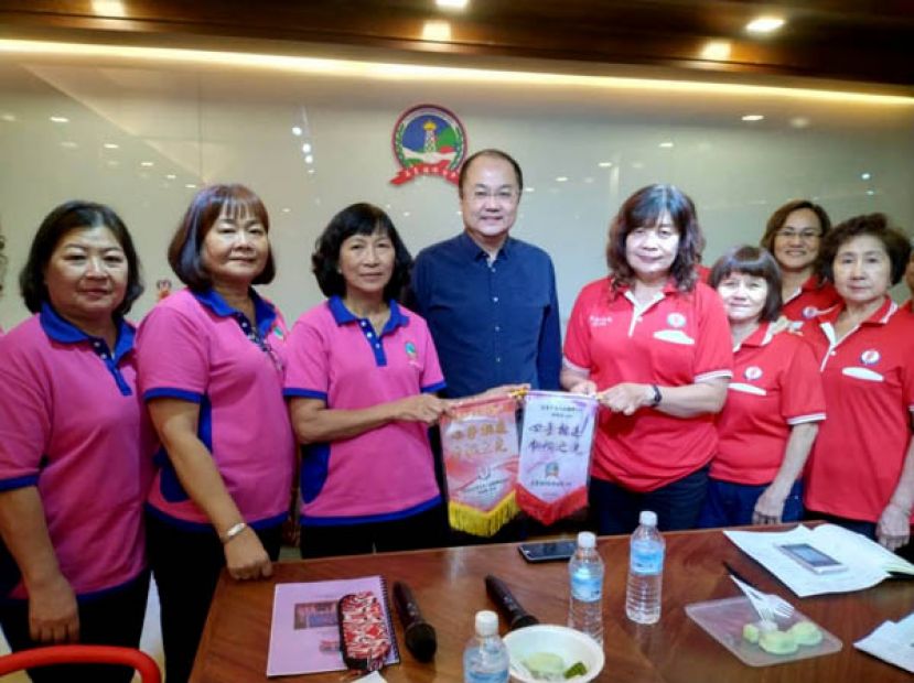 美里省华总妇女组与美里福州公会妇女组举行交流会，图为李瑞香(右3)及许美链(左3)在拿督吴健平(左4)见证下交换锦旗。