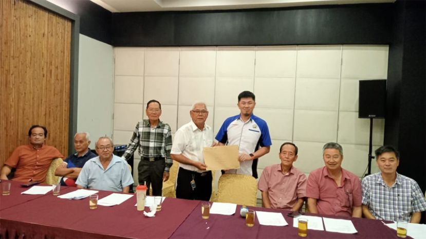 杨稳康（站者右）从原任会长庄永隆（站者中）手中接过委任状。