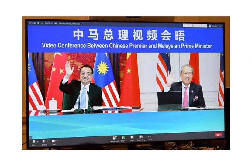 大马首相丹斯里慕尤丁（右）及中国总理李克强(左)举行视讯会议，商讨马中合作。
