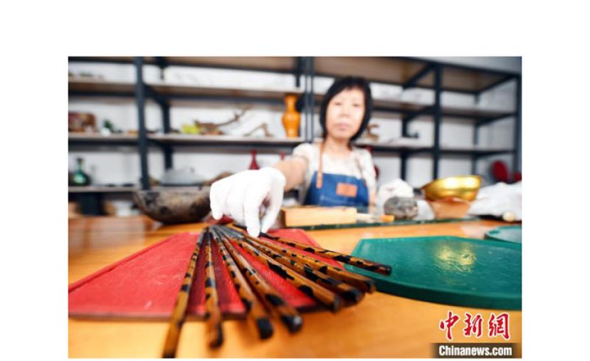 许晓芳对半成品筷子进行加工。