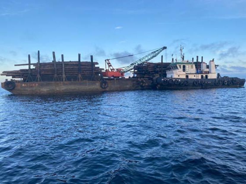 拖船与舯舡准备运载木桐离开美里水域。