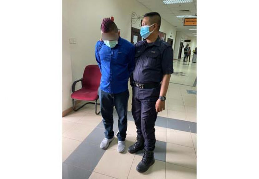 其中一名被告被押离开法庭时摄。