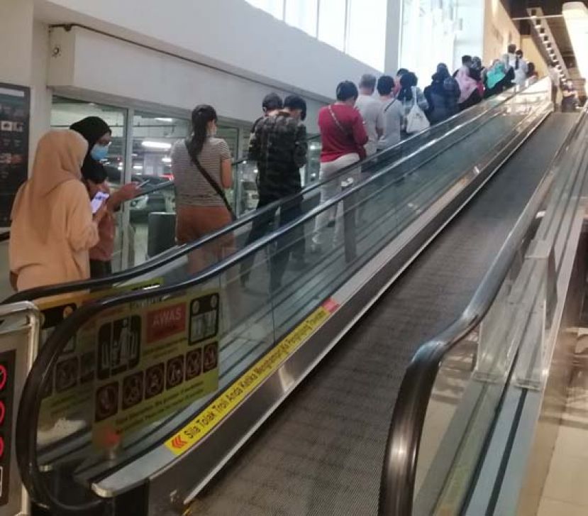 民众保持社交距离，列队进入购物商场。