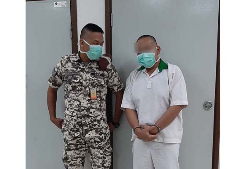 被告面对判决后，等候把押离法庭时摄。