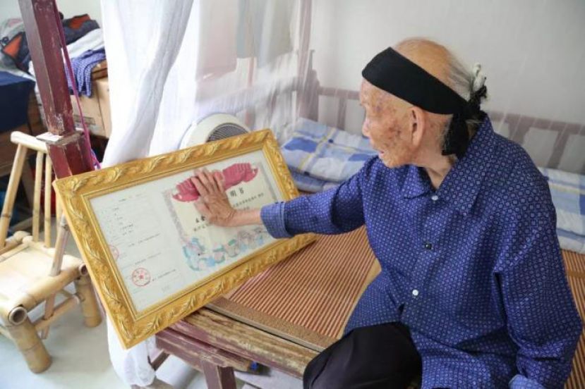 段桂秀轻抚着丈夫的烈士证明书。