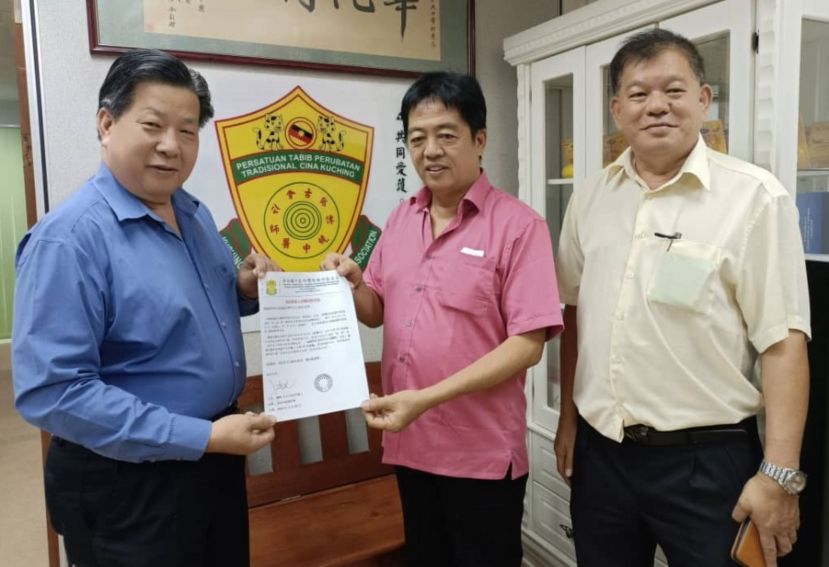 砂医总会长江宗兴（左）移交中医药论坛邀请函予毕打拿忠福宫主席许义华；右为砂医总会务顾问陈中兴。