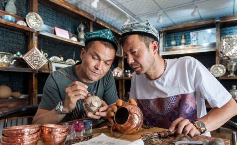 买买提&middot;卡地（右一）和弟弟玉素甫&middot;卡地在制作铜器。