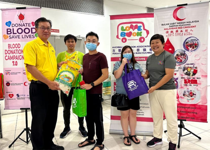 哥打圣淘沙区州议员叶耀星（左一），古晋爱心书协会创办人兼主席吕晗韵（右一）及理事郑永祥（左二）在二月份捐血活动中分发感恩礼包于成功捐血者。