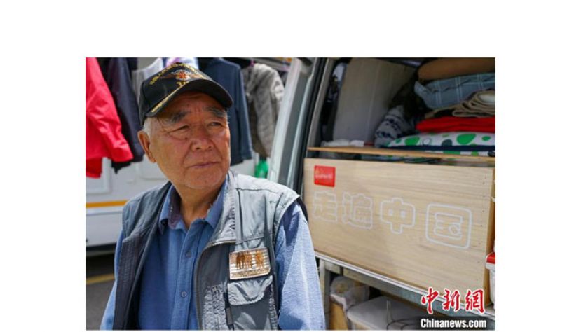 70岁的&ldquo;房车族&rdquo;苏钧，其身后车上写有&ldquo;走遍中国&rdquo;。