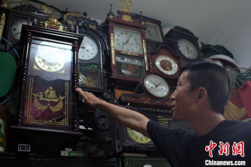 莫文刚正在介绍自己收藏的挂钟。