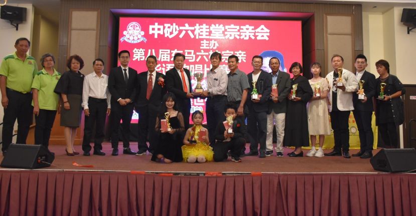 中砂六桂堂宗親會主席江宗興（左7)頒發歌賽團體總冠軍杯予副主席洪榮裕時與理事及歌手們合影.