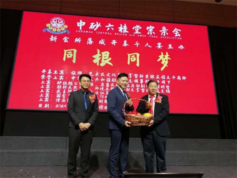 拿督斯里张庆信部长代表丁福营（中）由江宗兴手中接过水果礼蓝。左是筹委主席江邦发。