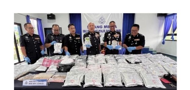 卡马鲁丁（右三）展示所起获的大批毒品。