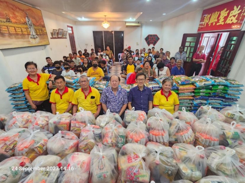 砂同心善堂主席黄国远（中）及理事与北市行政委员薛华东（右2）配合中秋节布施食品予80户弱势家庭。