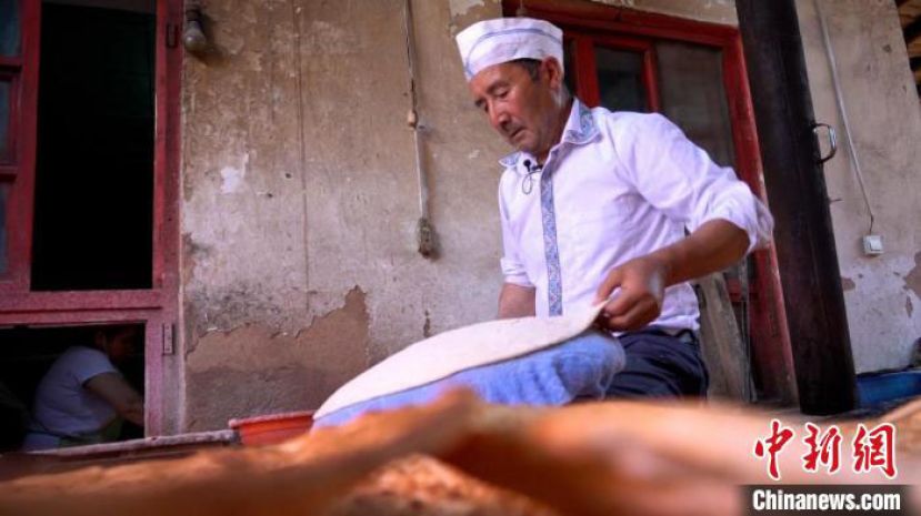 热西提&middot;依米提正在打馕。
