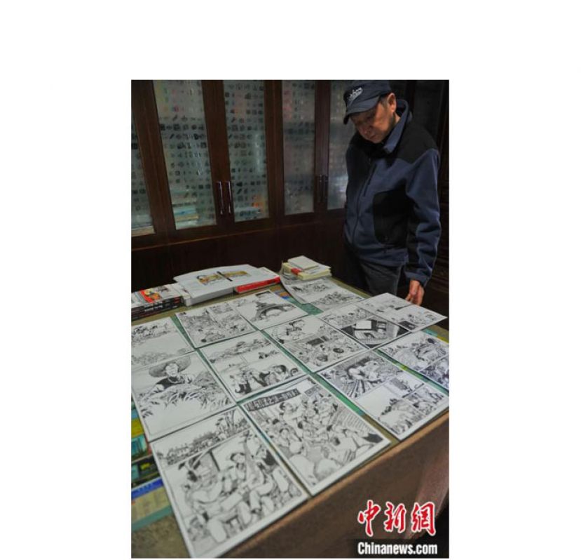 李昆武在工作室展示其漫画创作手稿。