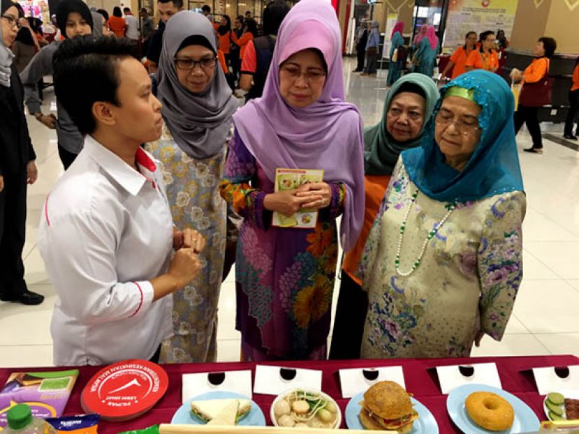 砂首长夫人拿汀巴丁宜拿督祖玛妮（右1）及砂福利、社会和谐、妇女、家庭与学前教育发展部部长拿督斯里陈赛明（中）巡视参展摊位时摄。