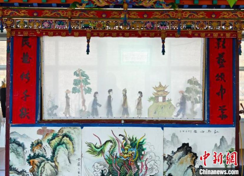 老艺人正在演唱关于新农村女性形象变迁的皮影戏。