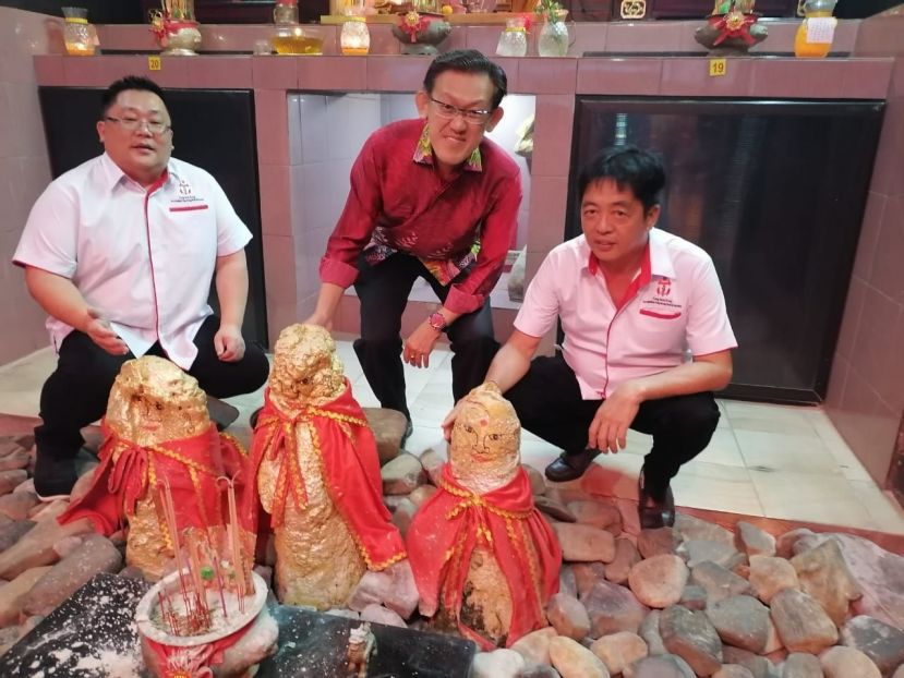 毕打拿忠福宫主席许义华（右起）向薛华东介绍该庙供奉三块灵石；左是副秘书张荣华。