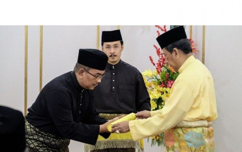 吉打苏丹端姑沙烈胡丁（右）颁赐州务大臣委任状予莫哈末沙努西（左）。