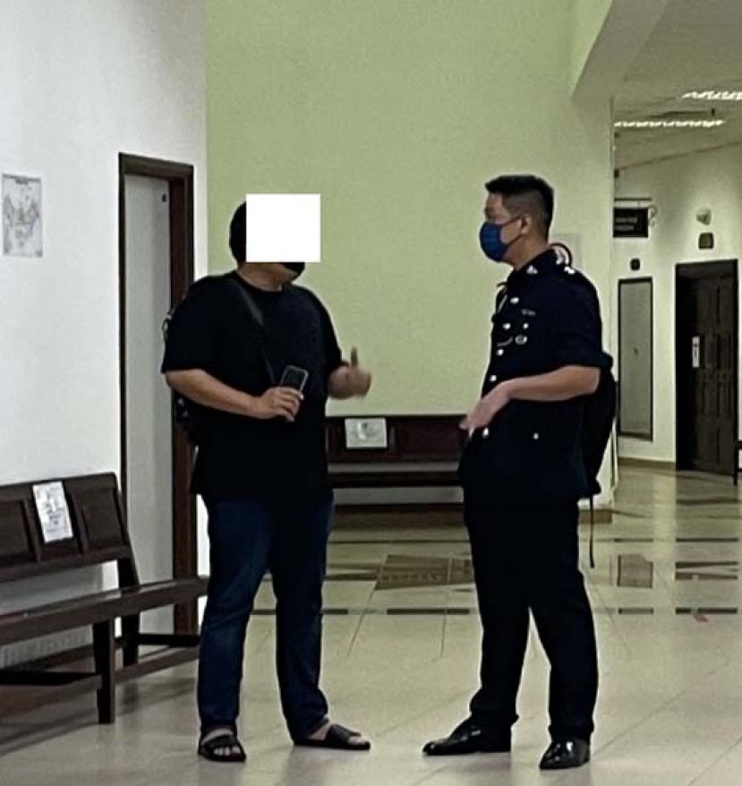 被告蔡某（左）和查案官交谈时摄。