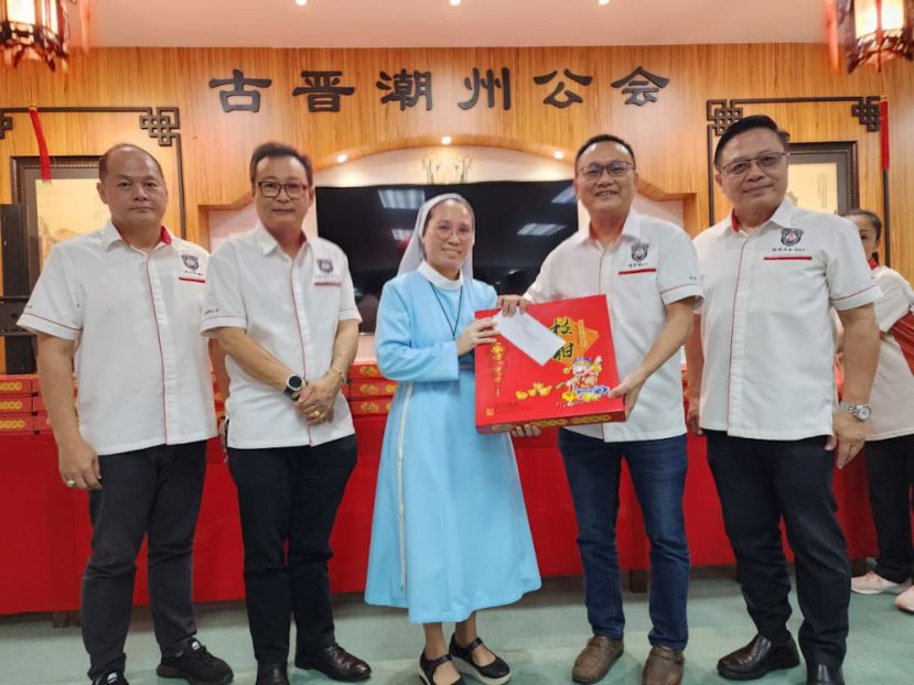 该会会长陈家福（右二）移交慈善捐款支票及赠送年柑予砂济世之家的代表（中）。右一是该会第一副会长陈瑞光、第二副会长拿督沈坚石（左二）及福利股主任沈士富（左一）。