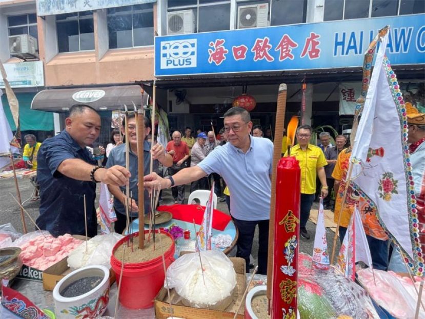 拿督黄良杰（中）代表砂副总理拿督阿玛沈桂贤出席古晋宝光村俱乐部联合宝光村六角亭处商家常年中元节祭祀活动。