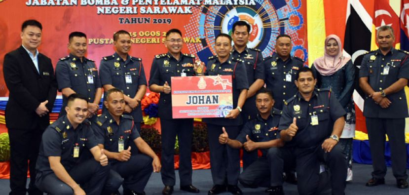 砂消防与拯救局局长凯鲁丁（左四）颁发革新与创新小组冠军予实文然消防革新与创新小组队员。