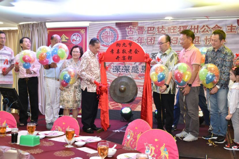 古晋巴达旺福州公会创会会长拿督斯里刘为强（左五）为午宴主持击锣仪式。