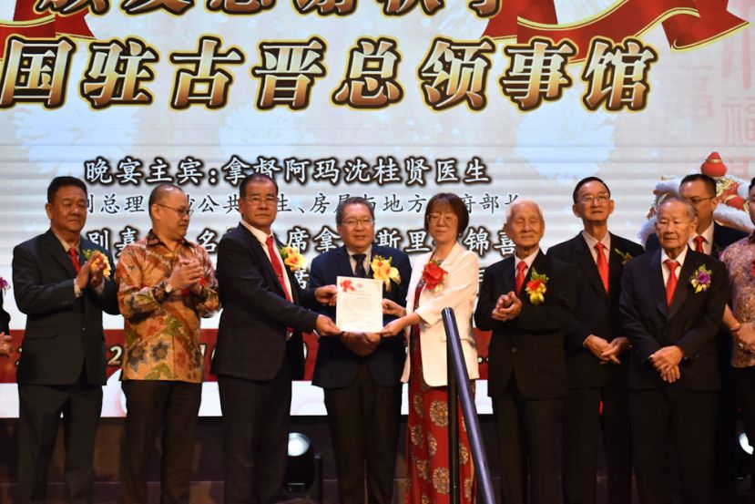 砂云南善堂主席郑文新（左三）移交感谢状予中国驻古晋副总领事宋长虹（右四），感谢中国驻古晋总领馆与云南善堂携手合作，捐赠大米援助贫困家庭，共同践行中华民族乐善好施、守望相助的优良传统。