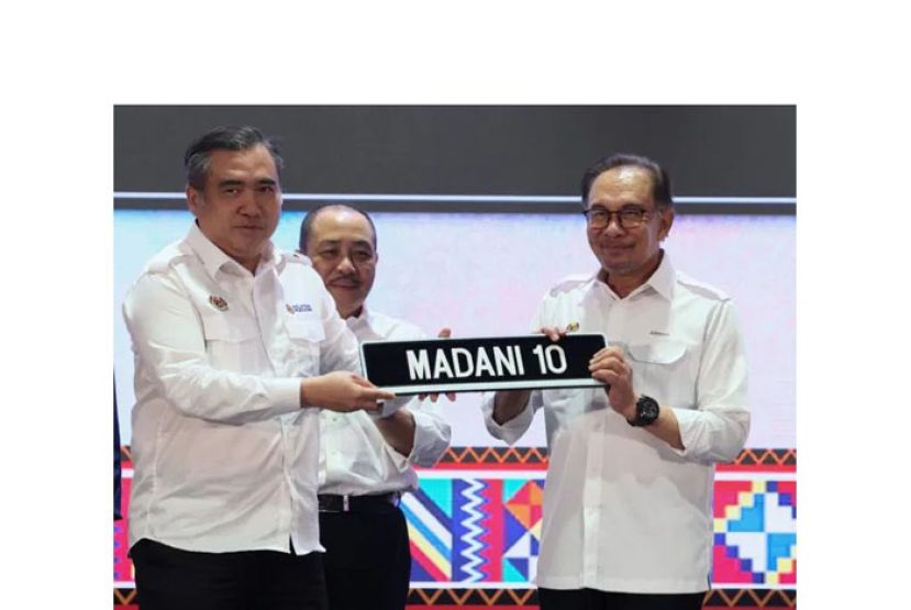 交通部长陆兆福（左）移交MADANI系列特别车牌给首相安华（右）。