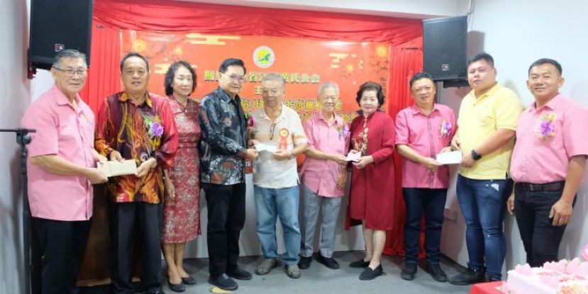 拿督吴标生（左四）移交支票予名誉主席黄乐之，林琴（右四）移交支票予黄茂青，天猛公郭翼升（右三）移交支票予团长黄聿丰，拿督黄天明（左二）移交支票予秘书黄乐仁。右为黄祥信，左三位拿汀黄秀容。